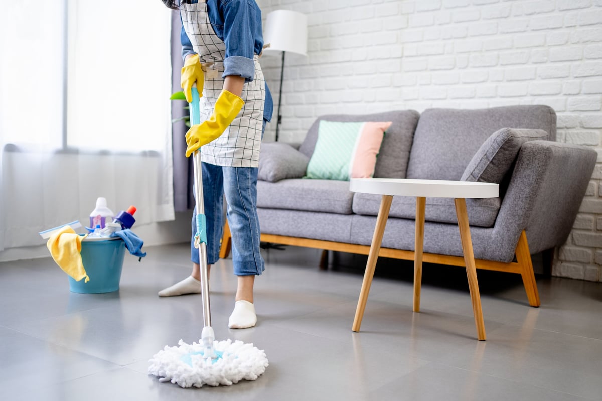 Cleaner wiping floors during a regular home cleaning visit